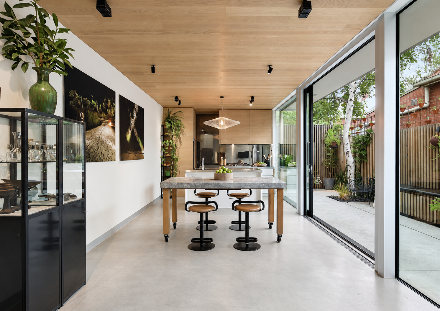 A light-filled residential interior with timber ceilings and a courtyard